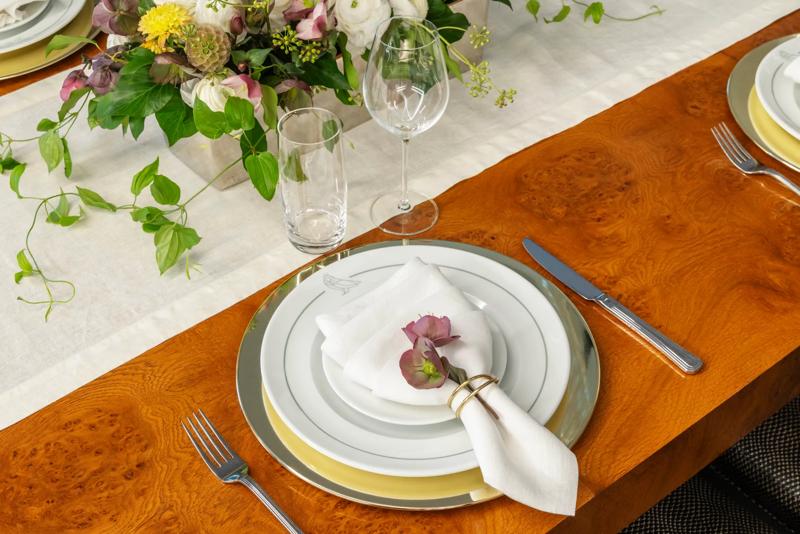 The plates and table decor on the dining table in the penthouse for a special event