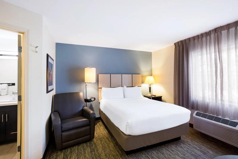 Studio sleeping space with bed, nightstands and recliner