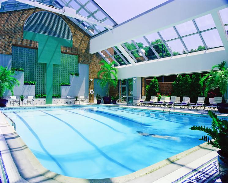 The indoor pool of the royal Sonesta Boston hotel with lounge chairs