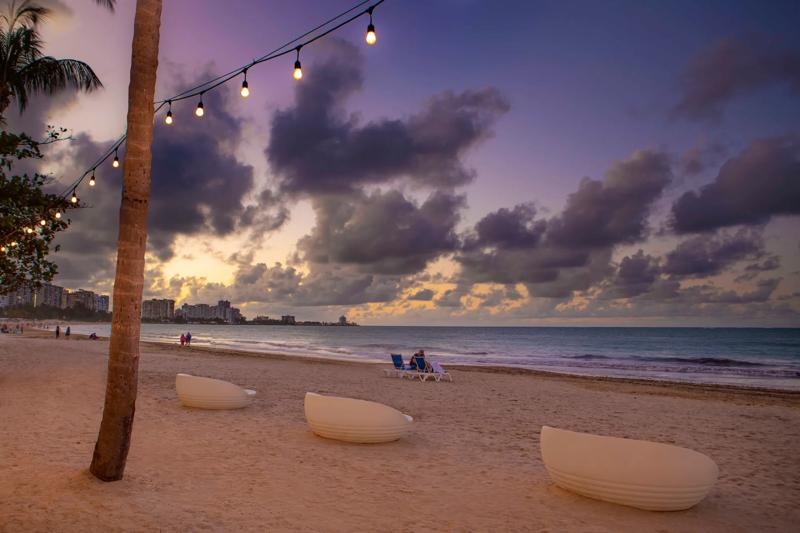 Seating on the beach by the hotel in the evening at sunset