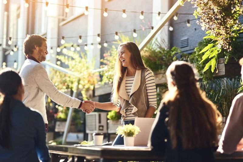 Cropped shot of colleagues shaking hands during a meeting at an outdoor cafe