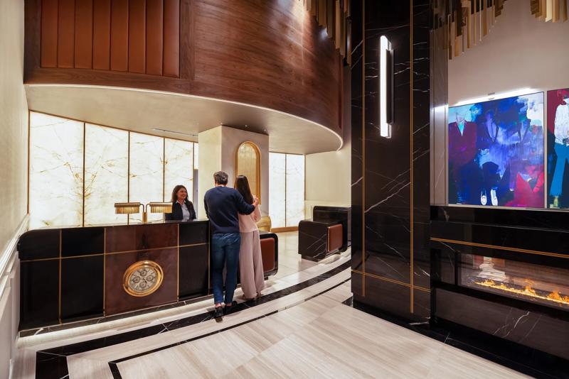 TRS_BenjaminNewYork_Lifestyle_Lobby_Couple Checking In - BA1558A3-C691-46DB-B2B46D895AA59FBA