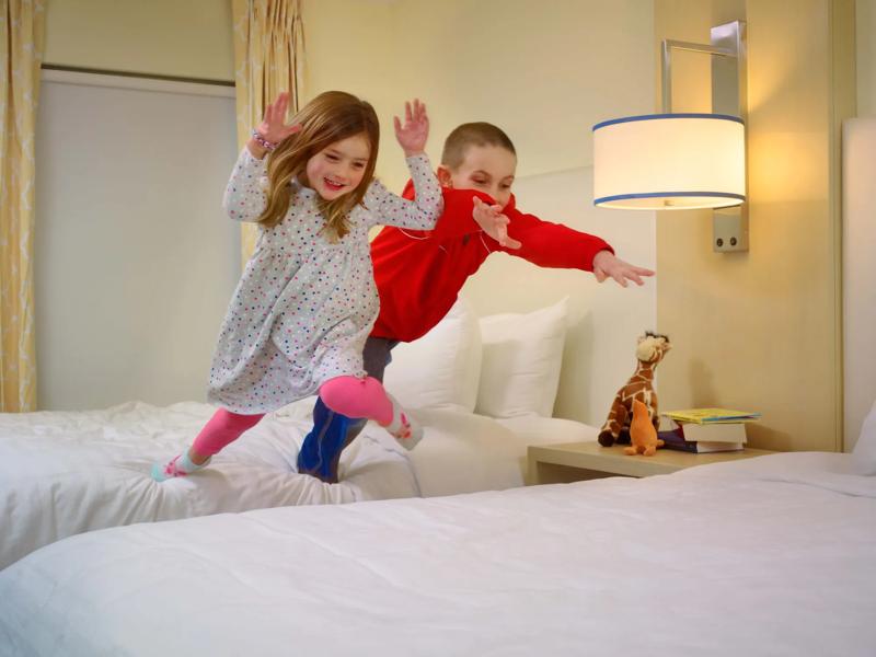 SES_Brand_AuburnHillsDetroit_Suite_TwoBedroom-DoubleBeds-WithKidsJumping-1 - BFFAEF6F-C72D-4800-83717FA47881C063