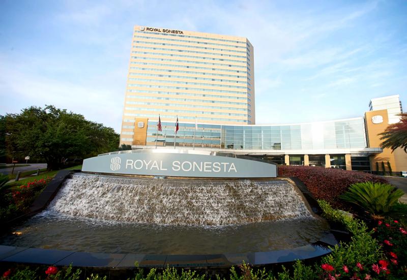 A front view of the hotel and front sign with a fountain