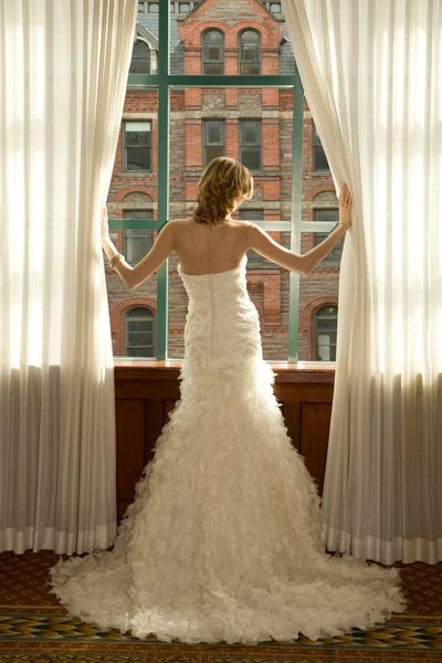 A bride looking out the window in her gown